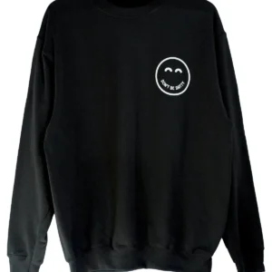 Black DON'T BE SHITTY smiley crewneck sweatshirt on a hanger
