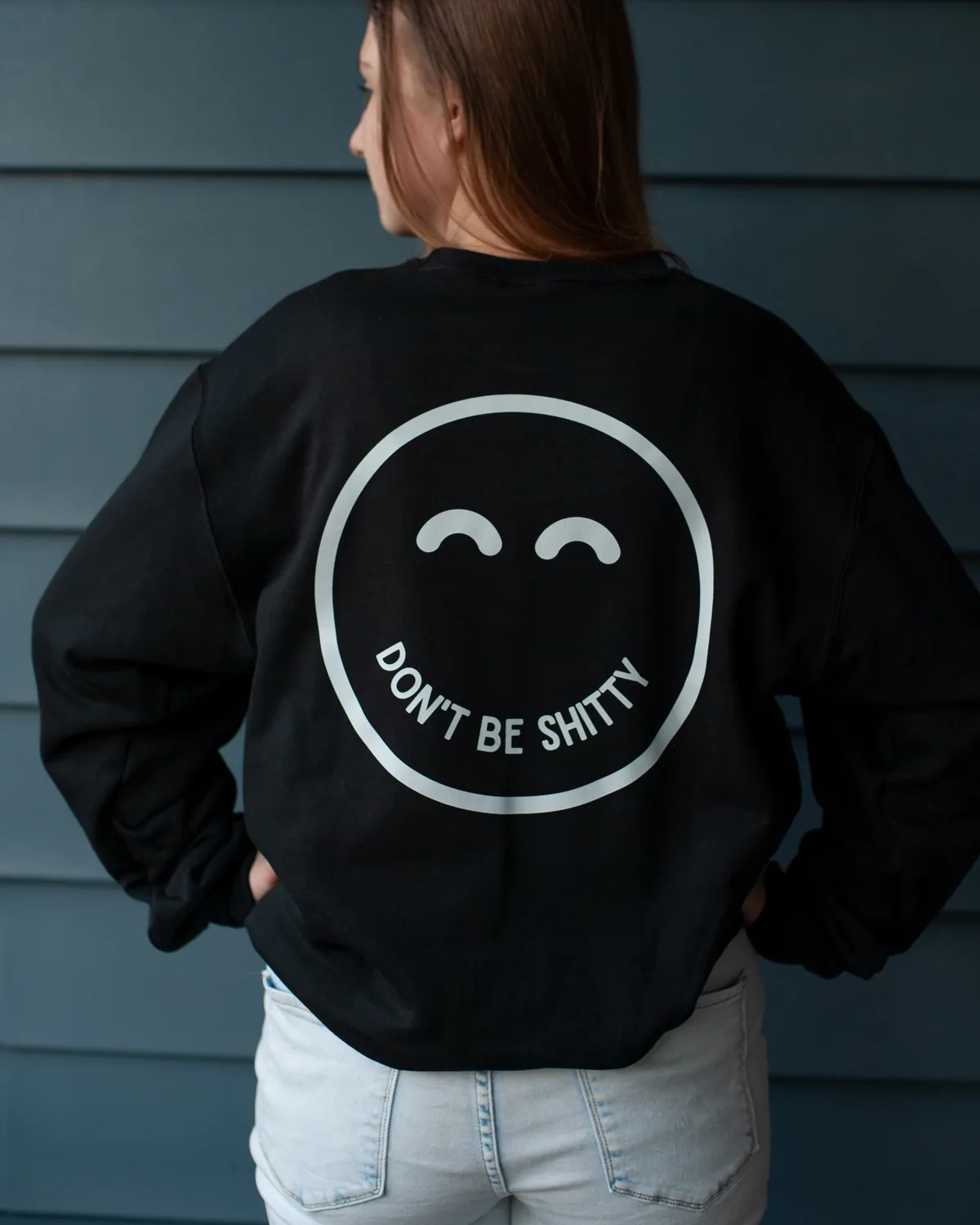 Back view of the black DON'T BE SHITTY smiley crewneck showing the large smiley print