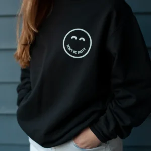 dbs-smiley-crewneck-black-worn-front Woman wearing the black DON'T BE SHITTY smiley crewneck sweatshirt