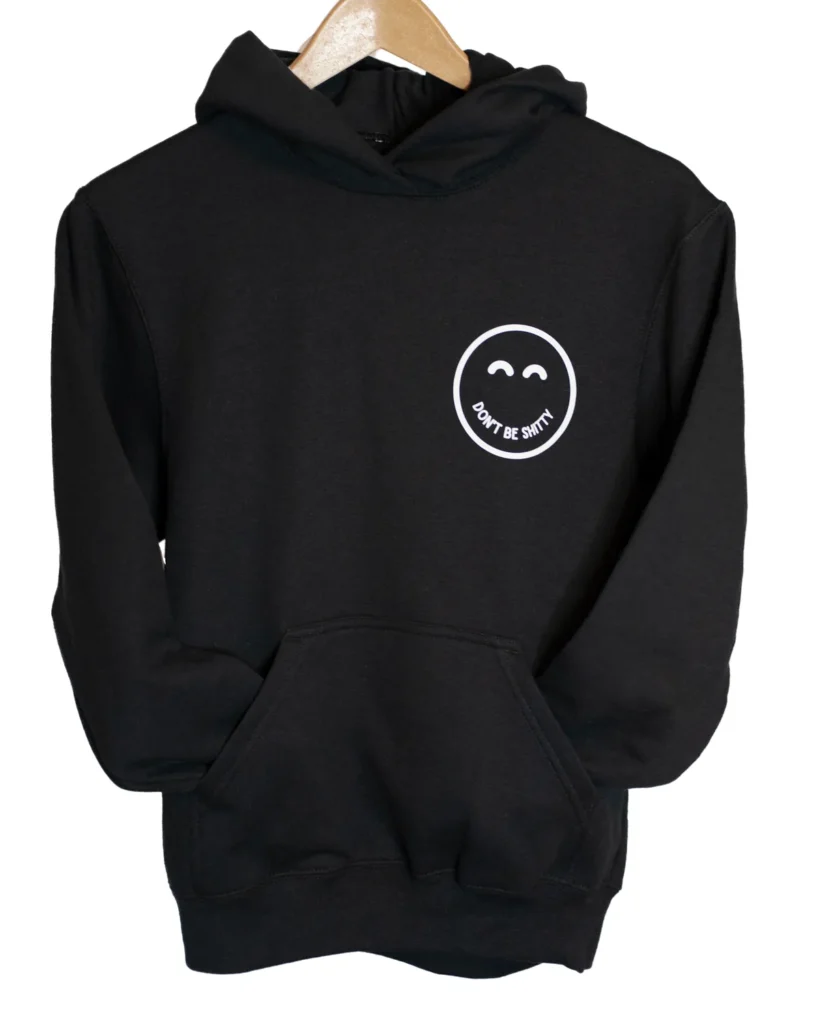 Black DON'T BE SHITTY smiley hoodie on a hanger, small smiley logo on the left chest
